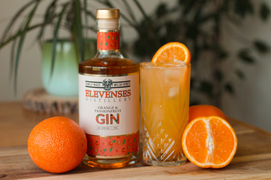 A bottle of Elevenses Orange and Passionfruit Gin alongside a refreshing cocktail